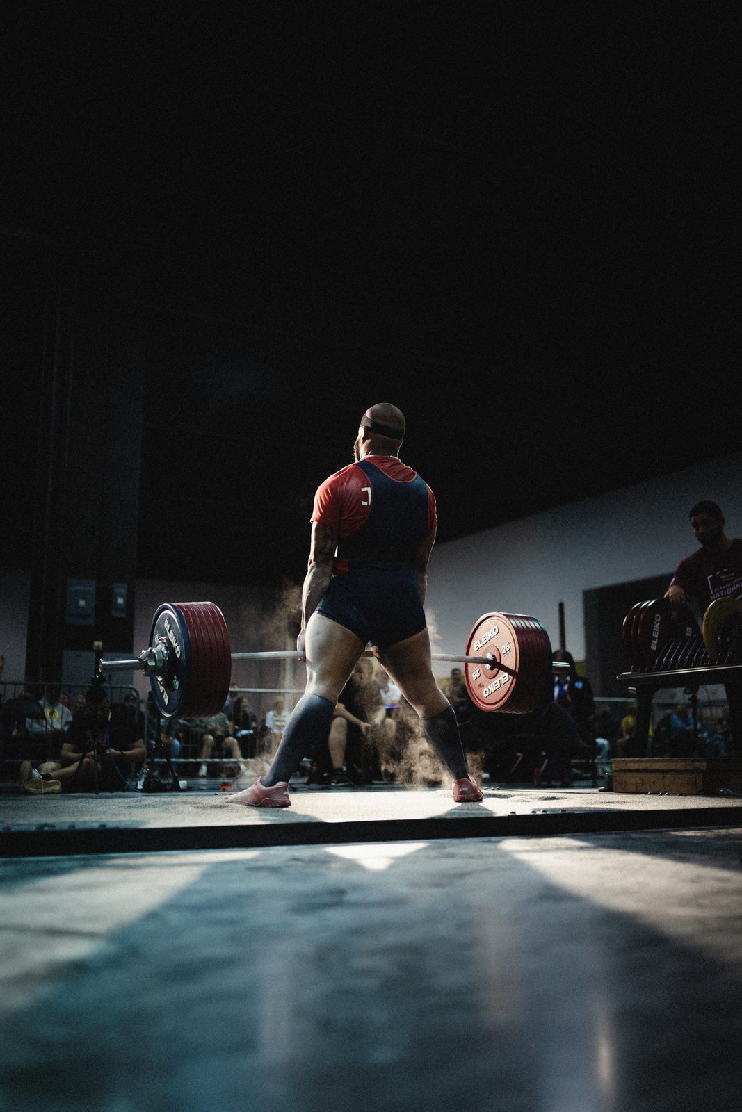 Lifter walking out to the bar under the lights